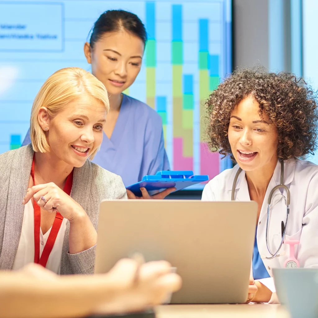 Healthcare professionals looking at the computer with their marketing partner